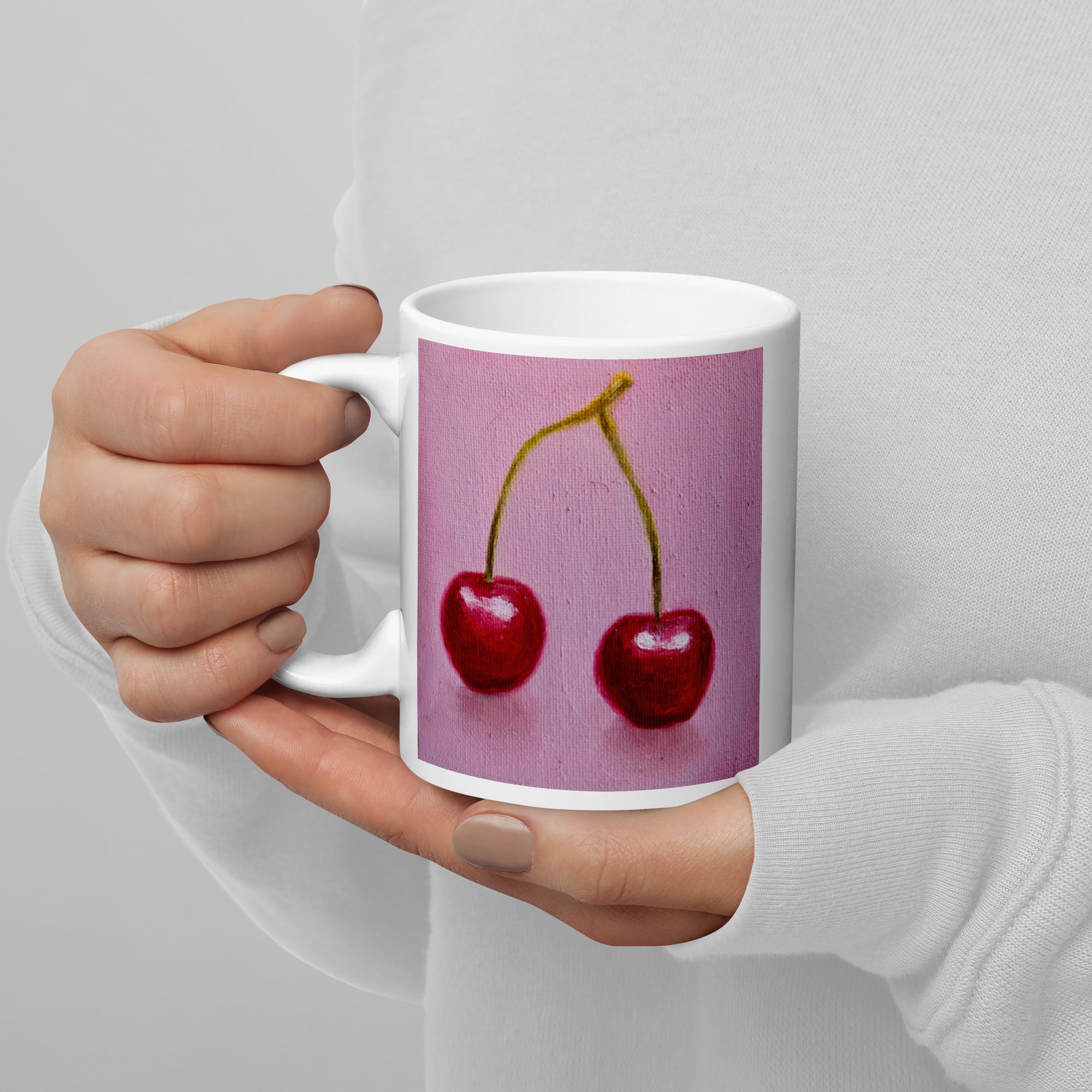 Red cherries on a pink background on a white mug